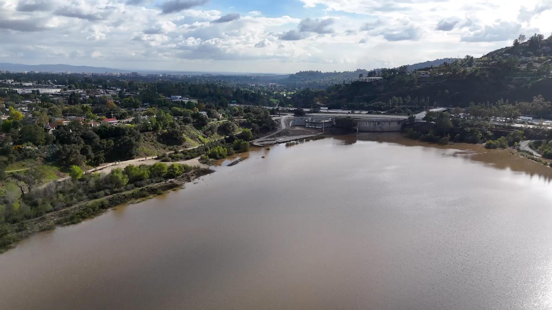 An aerial perspective of the Devil’s Gate Dam and its expansive reservoir basin, a key site for LA Water Projects, showing the water level and surrounding mountain landscape.