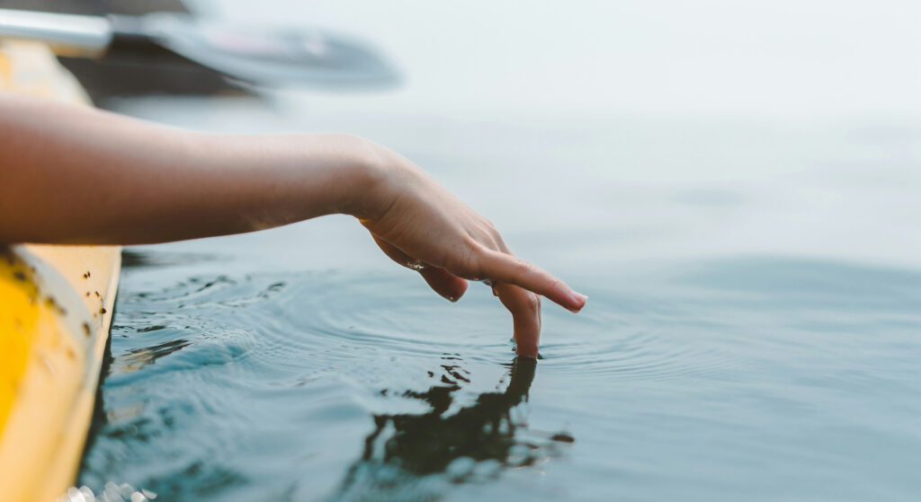 A photo of a hand touching the water