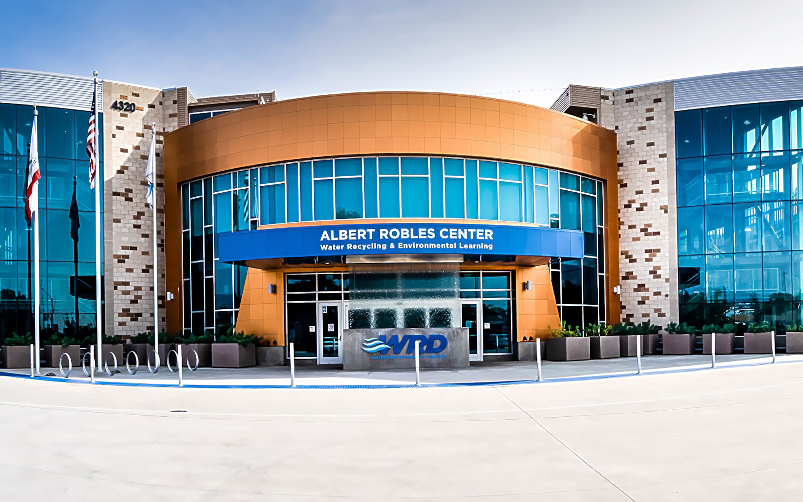 An exterior view of the modern, glass-fronted Albert Robles Center for Water Recycling & Environmental Learning, a premier example of Sustainable water infrastructure.