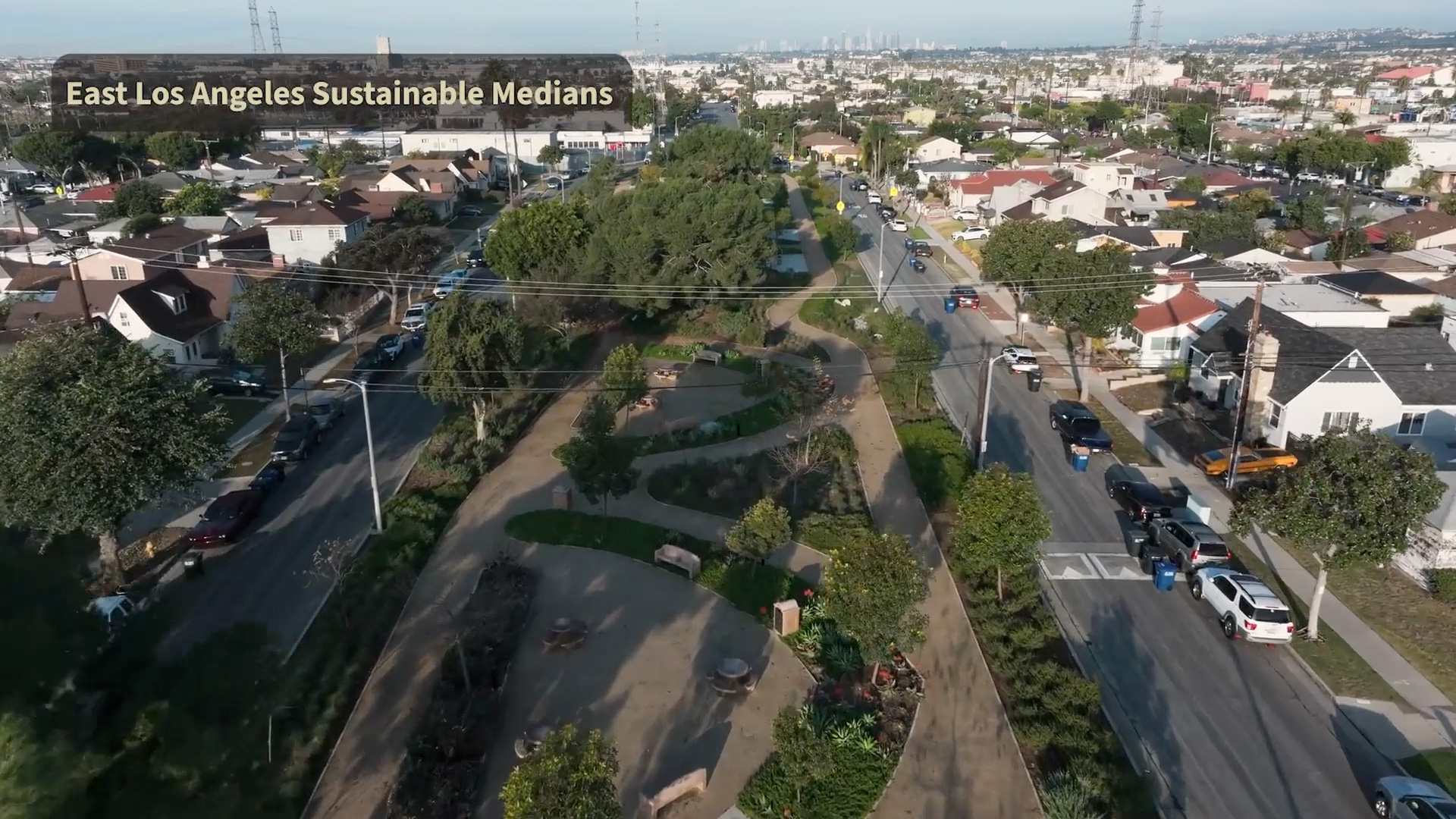 An aerial view of the East Los Angeles Sustainable Medians, a prime example of Multi-benefit water projects, featuring landscaped greenery and walking paths designed for stormwater capture within a residential neighborhood.