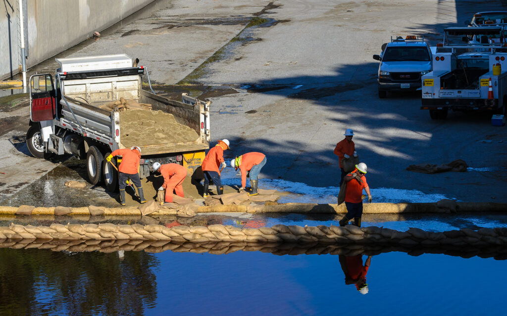 photo of a road crew working on a flooded street