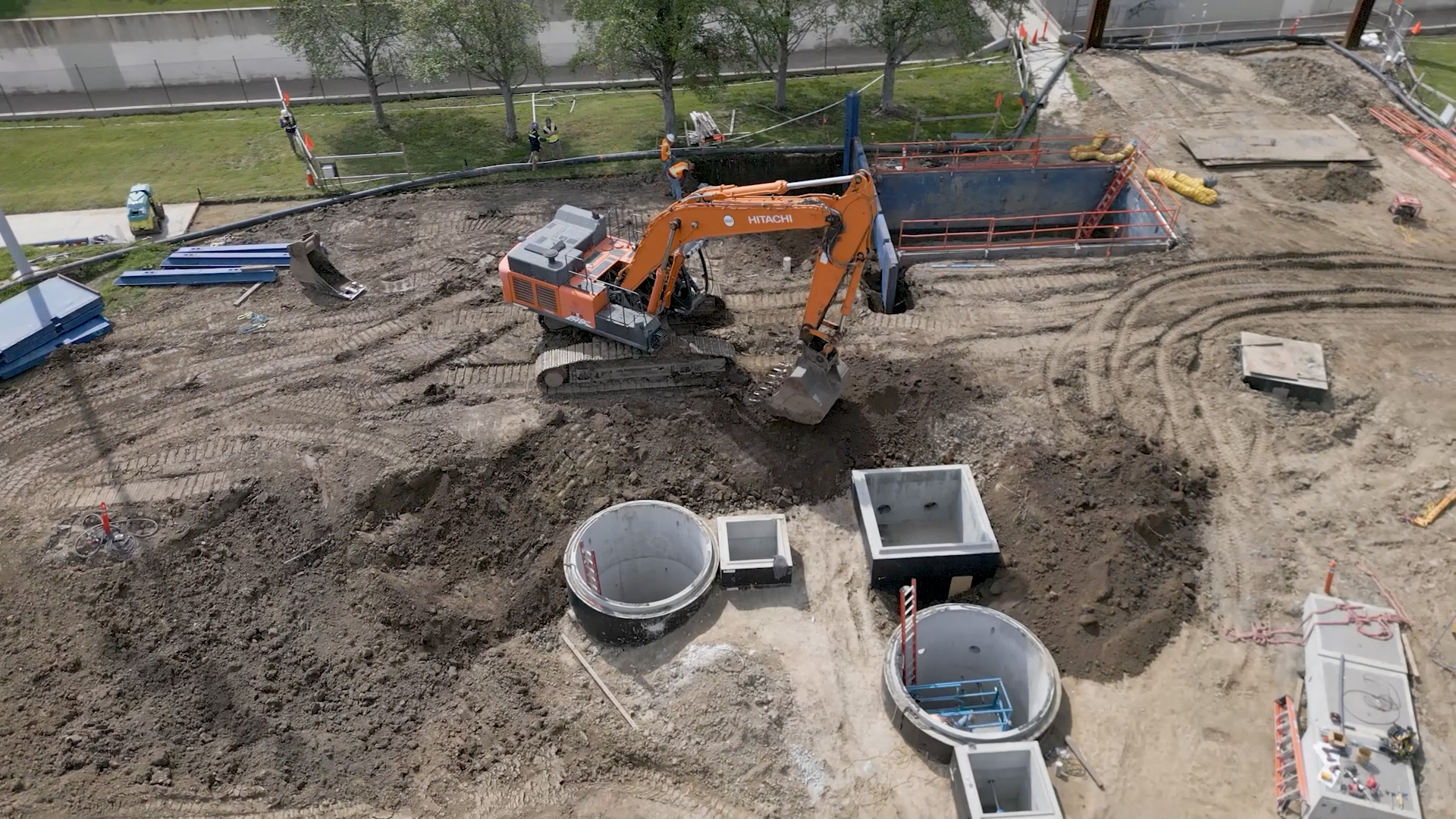 Aerial view of an orange excavator working at the Adventure Park multi-benefit project site
