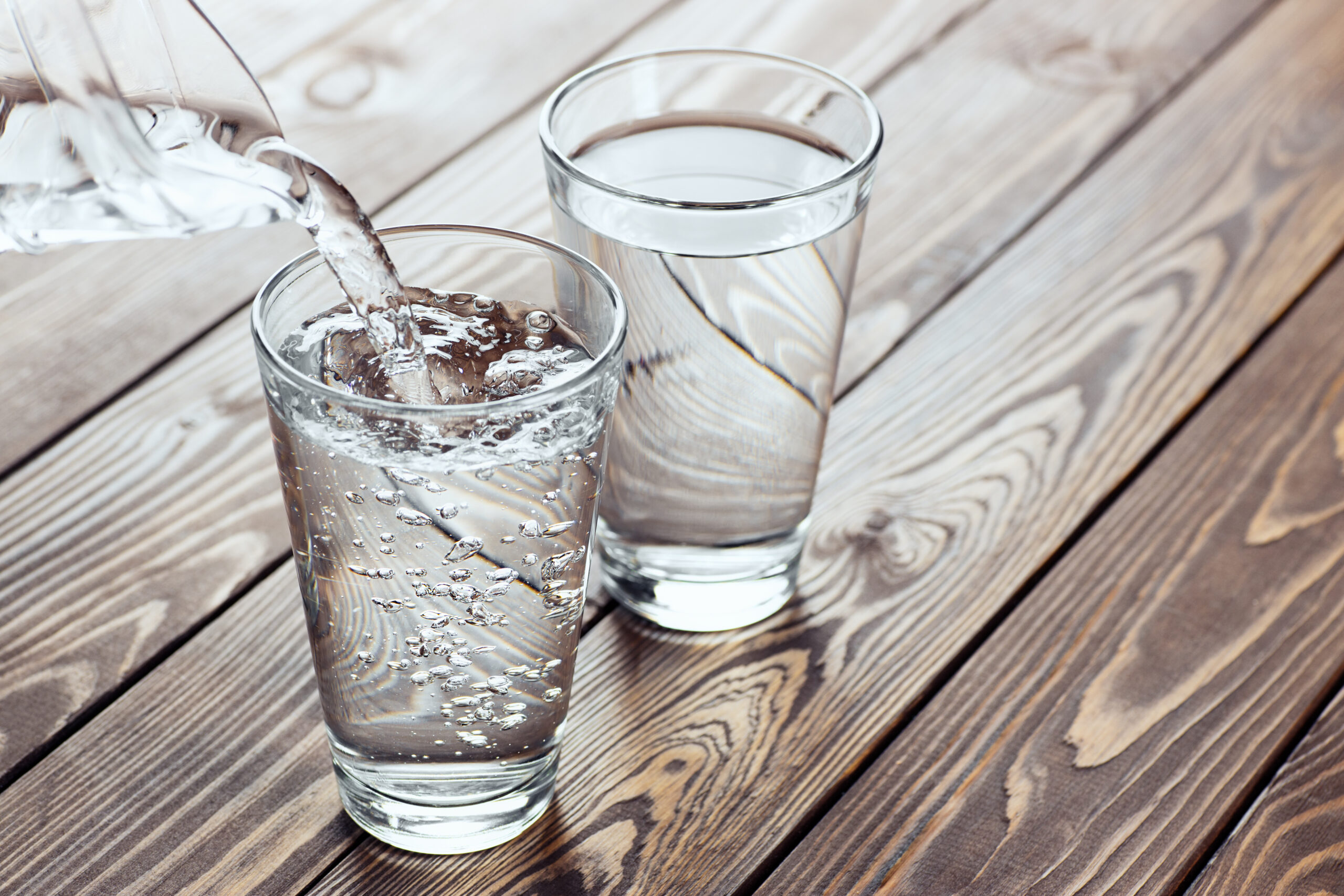 drinking water pouring from jug into glass on the table water pouring from jug into glass